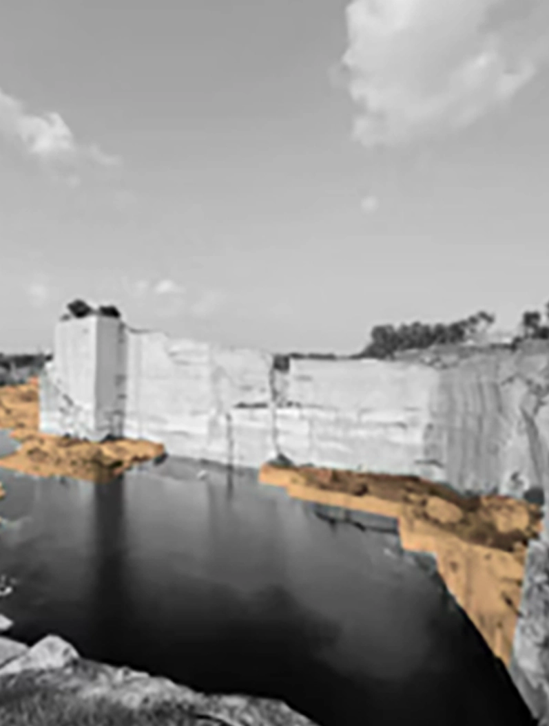 Rain-fed quarry basin held by tall pale granite walls.
